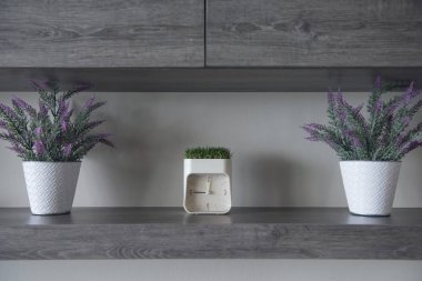 Modern iç. Güzel kokulu çiçekler ve bu çalar saat oturma odası, ahşap raf.