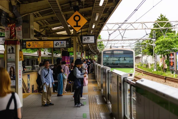Tokyo, Japonya - 7 Mayıs 2017: Unidentiified yolcu insanlar Harajuku platformu süre gelen Jr Tren İstasyonu'na neredeyse bırakır. İşte Japon cosplay sokak moda ünlü.