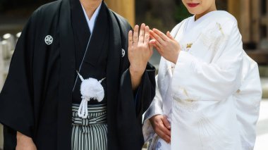 Japanese couple with traditional bride kimono and groom yukata uniform showing wedding rings by Closeup shot/