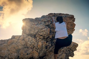 gün batımı sırasında üst hill kadar Aian kadın tırmanış hiking. Sportif kadın dağcı dağın zirvesi tepeye kadar ışınlarına karşı. İş veya açık spor başarı kavramı.