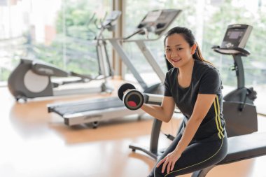 Mutlu Asyalı kadın portresi egzersiz Halter için metin kopya alanı ile spor salonunda ile. Sağlıklı kız eğitim vardır ve Spor donatımı tutun. Kol ve el spor yaşam tarzı için bina.