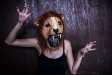 Korkmuş aslan maskesi koyu ahşap arka plan üzerinde olan kadın. Haloween fantezi elbise kavramı.