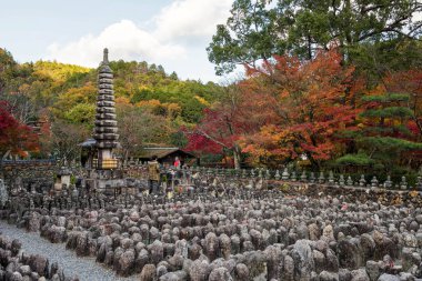 Japanses insanlar Arashiyama, Kyoto, Japonya sonbahar yaprakları renklerle Adashino Nenbutsuji Tapınağı'nda Buda heykeli selamlıyorum. Birçok taş Buda heykelleri sonbaharda pagoda Kulesi çevresinde.
