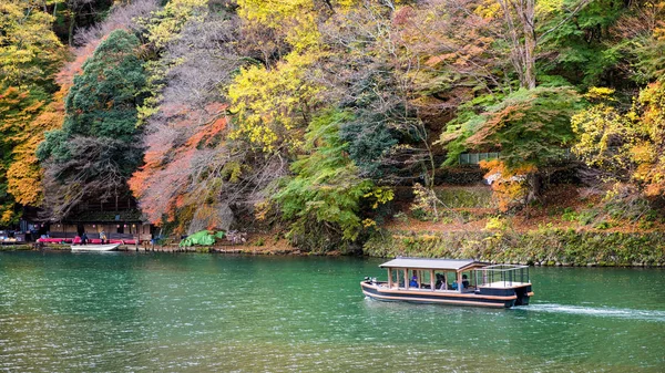 京都の秋の紅葉と桂川でセーリング観光船の色します ここでは 秋のシーズン中に有名な旅行のランドマーク — ストック写真