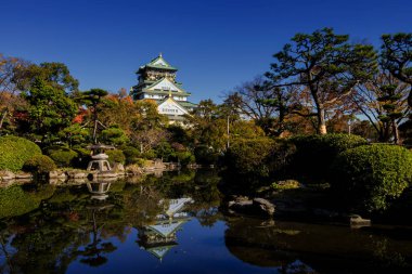 Osaka Kalesi sonbahar park, Kansai, Japonya'da bir havuzda yansıtan ile. Sonbahar yaprakları renkleri Bahçe.