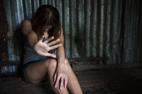 Sexual harassment or rape concept. Close up hostage girl hand protect herself from bad guy to be raped and suffered sex abuse in ruin room with blurred background and copy space for text.