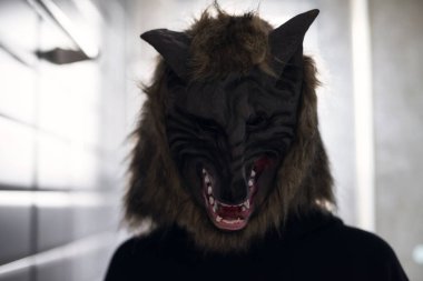 Kadın modeli ile kurt maskesi ve siyah elbise kostüm RIM penceresinden ışık ile karanlık odada. Korkunç insanların 2018 için Halloween kavramı kopya alanı için metin ile.