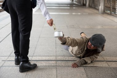 Bir ABD Doları bill para vererek eski iş adamı devre dışı kentsel şehir şehir yolda yatan evsiz adam. Yoksulluk sosyal sorunu konsepti için. Ve sempati ile pay vermek