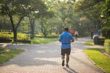 Çalışan veya gündoğumu doğal arka plan ile parkta koşu kıdemli yaşlı şişman adam. Yaşlı adam egzersiz ya da iş dışarı. Spor ve sağlık lifesytle kavramı.