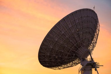 Alacakaranlık gökyüzü gün batımında karşı büyük uydu çanağı. Telekomünikasyon teknolojisi kavramı.