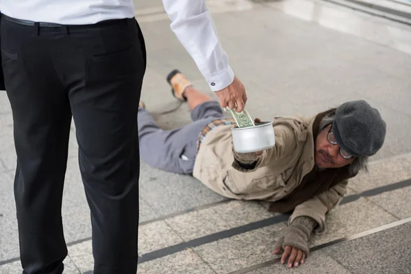 Businessman give money to handicapped homeless man — Stock Photo, Image