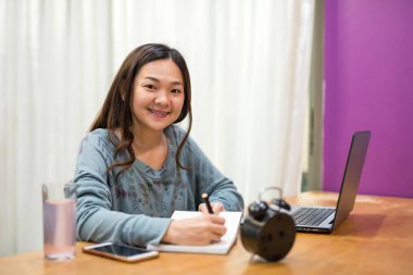 Asyalı öğrenci kitap okumak ve not almak