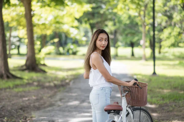 Menina atraente com bicicleta no parque — Fotografia de Stock