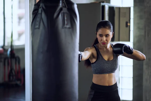 Kvinna Boxer Punch stans väska på gym — Stockfoto