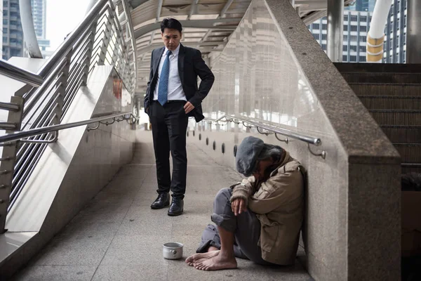 Mercy Businessman look at Homeless in city — Stock Photo, Image