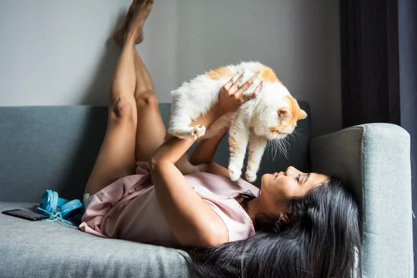 Mulher jogar com exótico gato shorthair no sofá — Fotografia de Stock