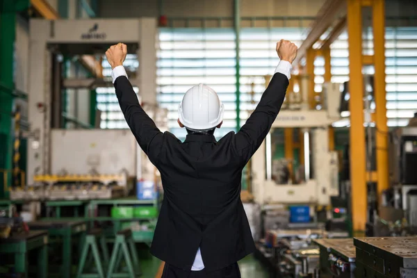 Gelukkige zakenman met helm in de fabriek — Stockfoto