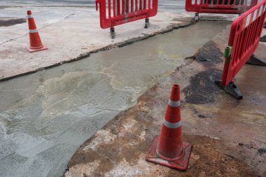 Karıştırıcı kamyonundan çimento döküp asfalt yolu tamir et ve kurumasını bekle. Halk sokağı için şehir inşaatı.