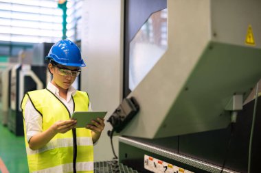 Fabrikadaki kurumsal uygulamayla tablet kontrollü ya da bakım makineli teknisyen kadın. Daha iyi bir endüstriyel iş elde etmek için denetim veya denetim süreci kavramı