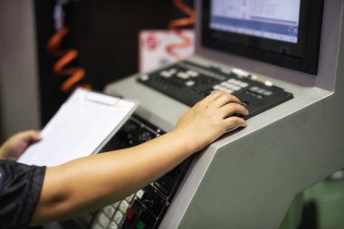 Elektronik üretim makinesinin kağıt işleme çalışma prosedürünü takip etmek için fabrika mühendisi el bilgisayarı. Modern teknoloji gereçleri ile sanayi üretimi.