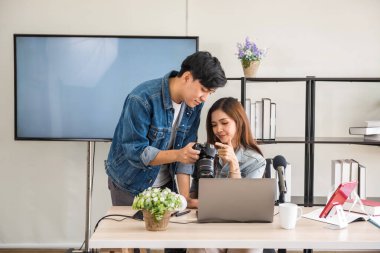 Sahne arkası konsepti. Profesyonel fotoğrafçı, stüdyosu olan güzel Asyalı kadın blogcuya resim gösteriyor. Yayın vlogger, internet etkileyiciName.