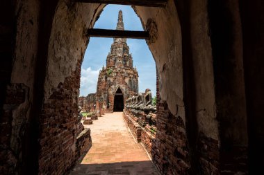 Wat Chaiwattanaram, güneşli bir günde mavi gökyüzü, Ayutthaya, Tayland 'da Buda heykelini harabeye çeviren büyük kapı girişinden. Tarihi tapınakta tarihi mimari ile ünlü seyahat merkezi..