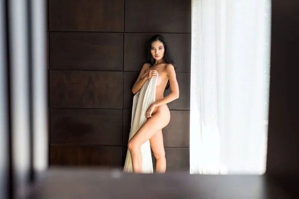 白い布で体をカバーする裸のアジアの美しい女性の肖像画 木製の棚スタジオを介してエロティックな写真 セクシー官能的な魅力的な女の子 — ストック写真