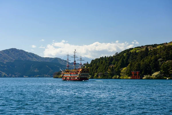 Red pirate tourist cruise sailing through red torii gate of Hakone shrine at Ashi lake with mountain fuji background. The pirate ship is one of the most famous Hakone tourist wishlist.