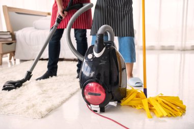 Ev yatak odasını temizlemek için elektrikli süpürge ve paspas kullanan çift. Hijyen ve sağlık yaşam tarzı konsepti. Hafta sonu ev işi. ev yapımı elektronik makine