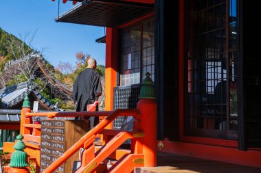 Budist keşiş, sonbaharda Bishamondo tapınağı terasında mavi gökyüzü, Kyoto, Japonya 'da yürür. Aralık ayında Kansai 'nin ünlü tatil beldesi.