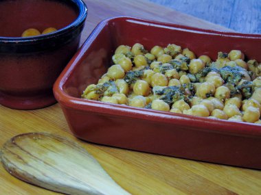 Tahta kaşıkla seramik tabakta ıspanaklı nohut.