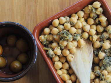 Tahta kaşıkla seramik tabakta ıspanaklı nohut.