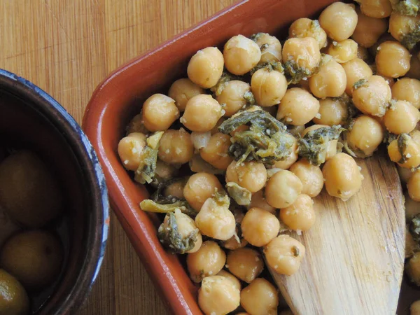 Tahta kaşıkla seramik tabakta ıspanaklı nohut.