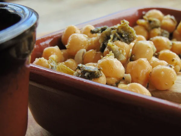 Tahta kaşıkla seramik tabakta ıspanaklı nohut.