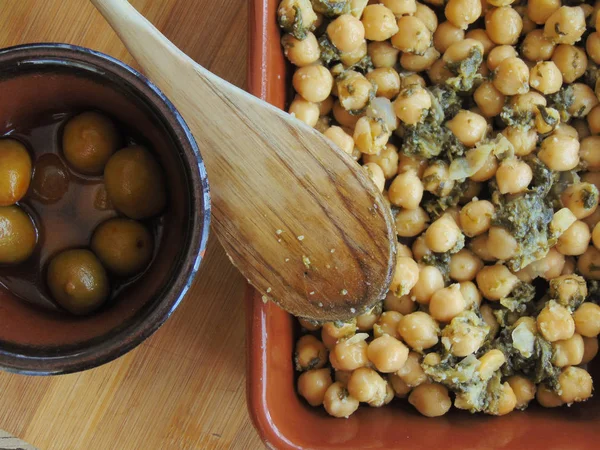 Tahta kaşıkla seramik tabakta ıspanaklı nohut.
