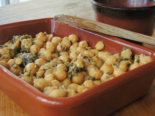 Tahta kaşıkla seramik tabakta ıspanaklı nohut.