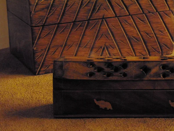 Incense box on a rustic table with a trunk of wood.