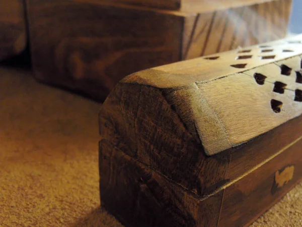 Incense box on a rustic table with a trunk of wood.