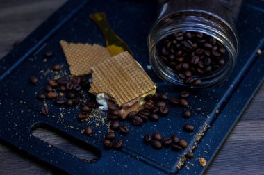 Waffle ve kahve çekirdekleri yanında vanilya, çikolata ve dondurma kesme.