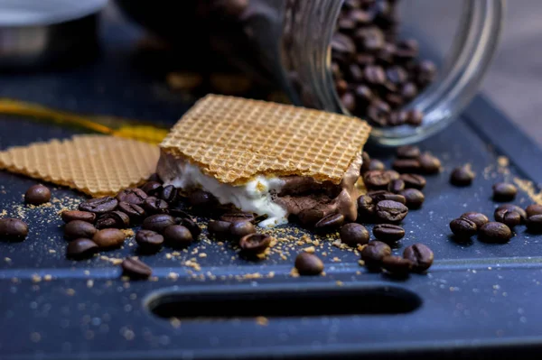 Waffle ve kahve çekirdekleri yanında vanilya, çikolata ve dondurma kesme.