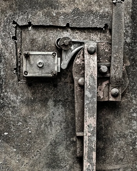 A grungy, rusty, old door locking mechanism.