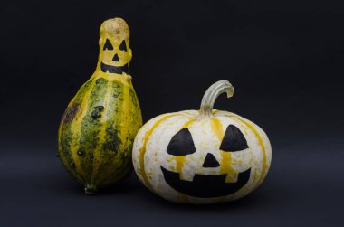 Şirin Halloween pumpkins mutlu ifade siyah arka plan ile. Cadılar Bayramı Balkabağı başkanları ile siyah arka plan üzerine gülümsüyor