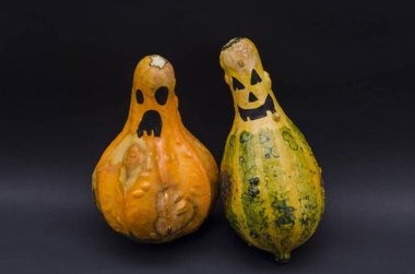 Şirin Halloween pumpkins mutlu ifade siyah arka plan ile. Cadılar Bayramı Balkabağı başkanları ile siyah arka plan üzerine gülümsüyor