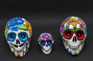 El Strafor kafatasları çiçekler siyah arka plan ile boyalı. El Cadılar Bayramı ve Meksika gün ölü dekorasyon için kafatasları boyalı