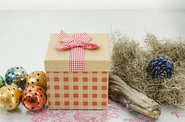 Weihnachtsgeschenk Mit Roter Schleife Einer Komposition Mit Weihnachtsmütze Weihnachtsbaum Weihnachtskugeln — Stockfoto