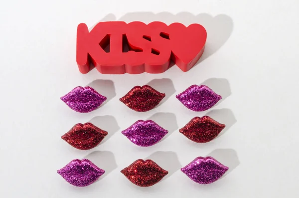 The word kiss and little red and purple lips against white background. Valentines Day decoration