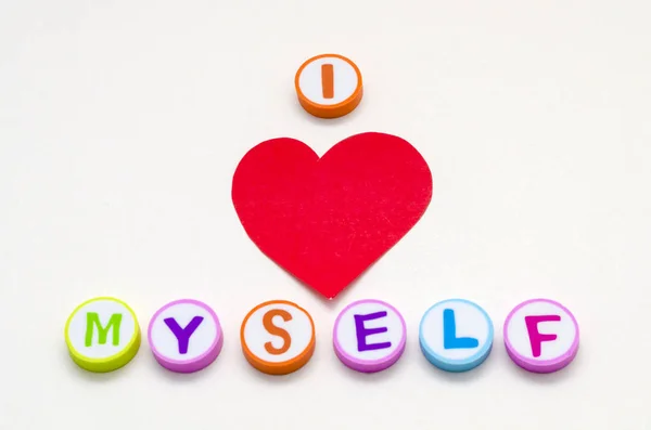 I love myself phrase made from colorful circles with letters and a red heart against white background