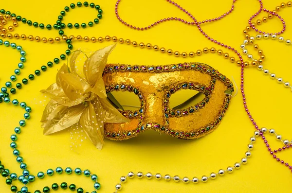 Traditional Venice carnival mask. Man and woman ball masque for theater or opera, mardi gras festival or brazil parade. Fashion and holiday theme with colorful beads on yellow background