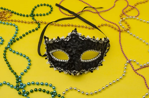 Traditional Venice carnival mask. Man and woman ball masque for theater or opera, mardi gras festival or brazil parade. Fashion and holiday theme with colorful beads on yellow background