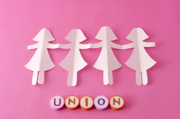 纸玩偶链子和联合由五颜六色的信件在粉红色背景 — 图库照片